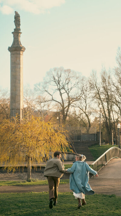 Couple Holding hands and running off at Allegheny Commons Park Engagement