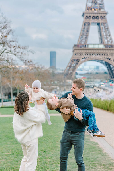 Mother, Father and two children playfully posing by Eiffel Tower at Trocadero Family Photoshoot in Paris