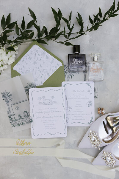 Flat lay of wedding invite green envelope white invite with green details on the invite. 