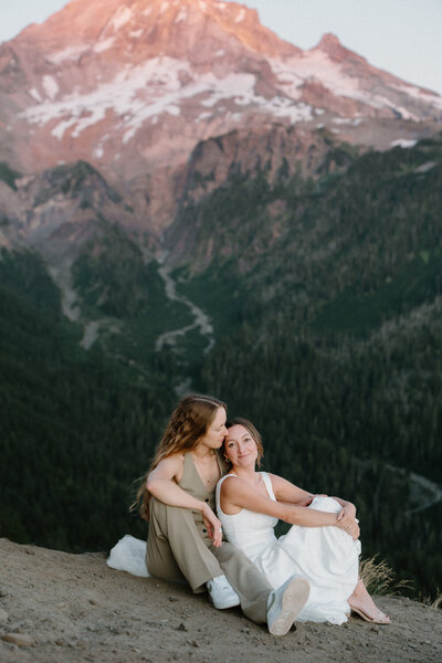 A couple holds hands in front of a coastal view during their elopement