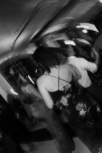 A slightly blurred photo of guests dancing at a wedding reception 