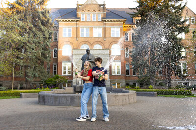 graduation photo of a blonde female popping champagne by a Gonzaga graduation photographer