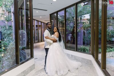 Bride and Groom share a kiss in front of their cheering wedding party at the Avenue of the Arts Hotel in Costa Mesa