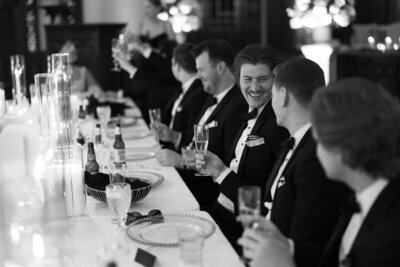 Guests laughing and toasting during a lively reception, captured by a Wisconsin wedding photographer.