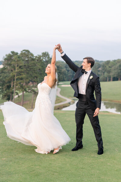 groom twirling bride on greenville country club golf course wedding