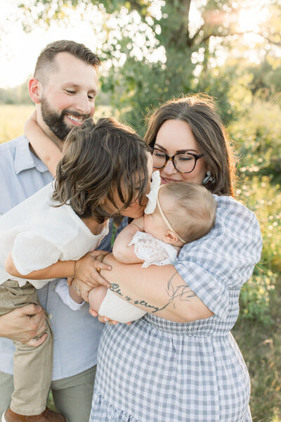 MKE WI Family Photographed in field during sunset brother kisses baby sister