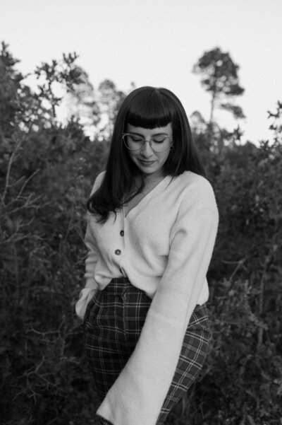 A black and white photo of Ashley Joyce smiling and looking towards the left side of the frame