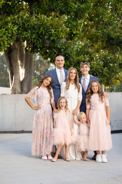 Family in a group wearing pink and soft colors