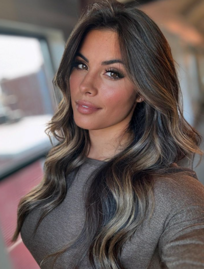 Woman with dark, soft balayage hair styled by Salon Beau, showcasing a natural, dimensional finish.