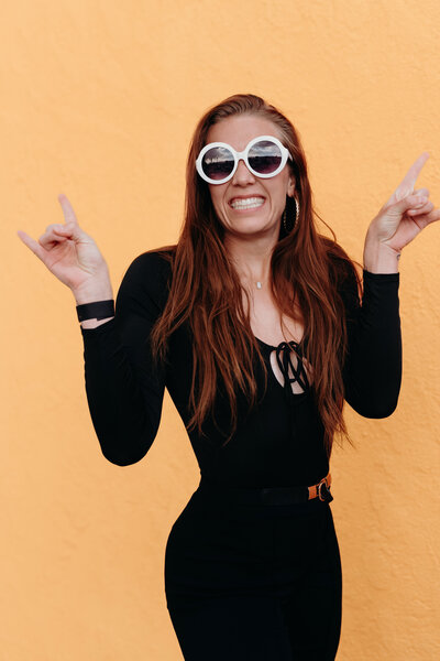 A woman member of the LIVE BIG Collective posing confidently with sunglasses on 