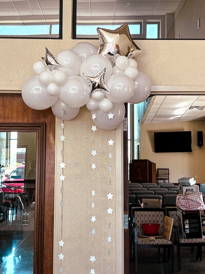 ballon art of silver stars sitting on a white cloud with sparkles flowing underneath