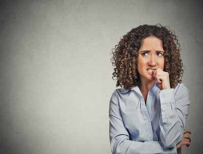 Woman biting nails wondering how to get rid of anxiety.