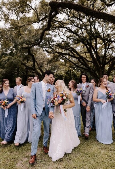 A wedding party walks to a wedding hold luxurious flowers in central Texas.