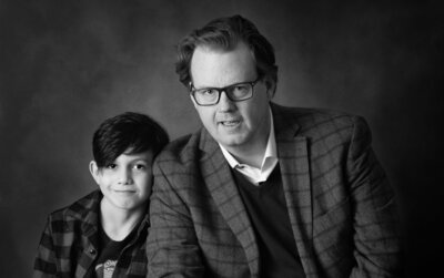 black and white portrait of father with his son who is leaning his head on his dad's shoulder