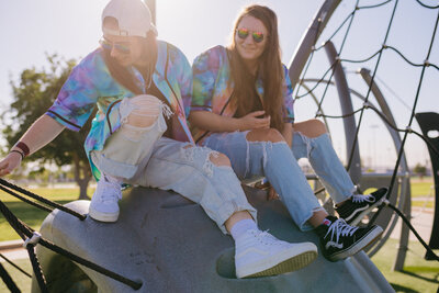 Two friends sitting together at a playground.