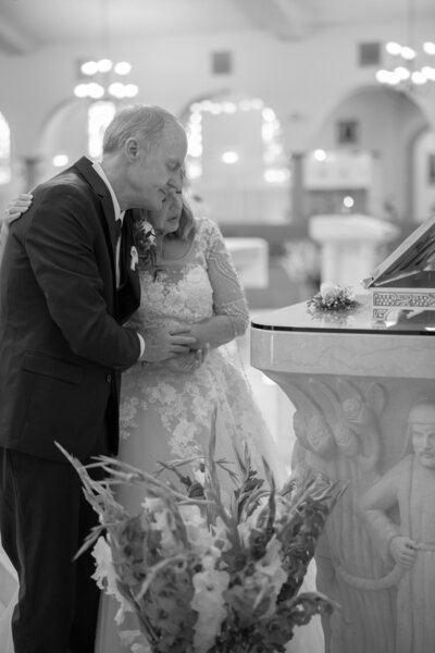 bride and groom praying during the ave maria at a las vegas catholic church during their wedding mass taken by alexis dean photography