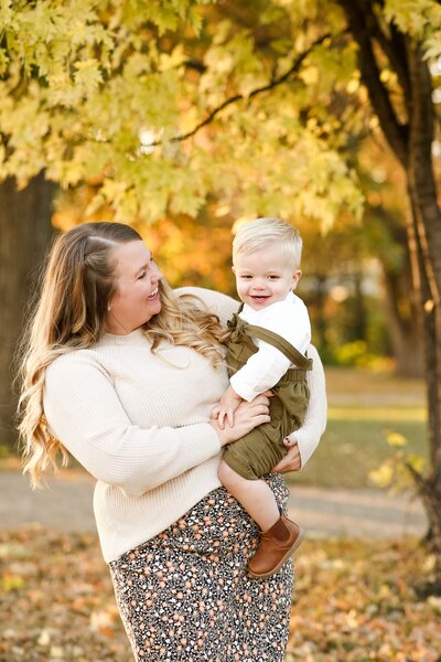 Mom and toddler surrounded by fall colors in Fargo, ND