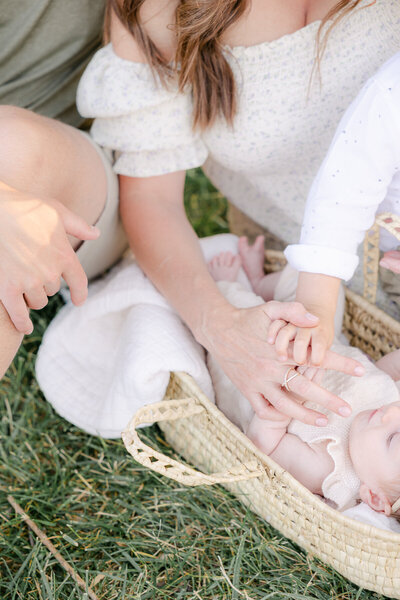 Close up of mother and son holding newborn's hand while laying in Bassinet, Central Indiana Family Photographer