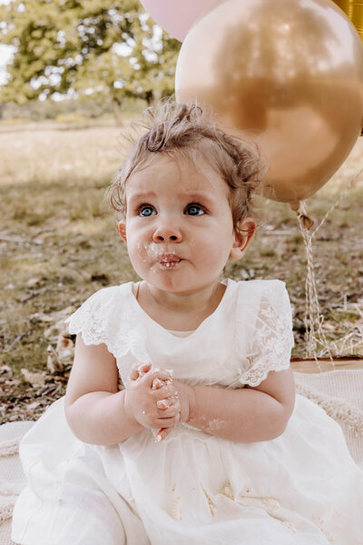 Portret foto van een meisje tijdens haar cakesmash fotoshoot van 1 jaar