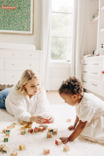 mother and her toddler playing in a room taken by a natural light photographer