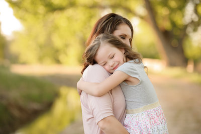Daughter hugging her mom with her eyes squeezed tight during family photography session in Boise, Idaho with Tiffany Hix Photography