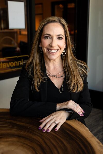 Mary Beth smiling in a chair perfect for personal branding photoshoot personal style and positive interactions.