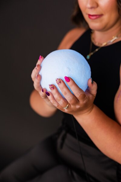 Woman holding a white moon lamp shaped like a ball