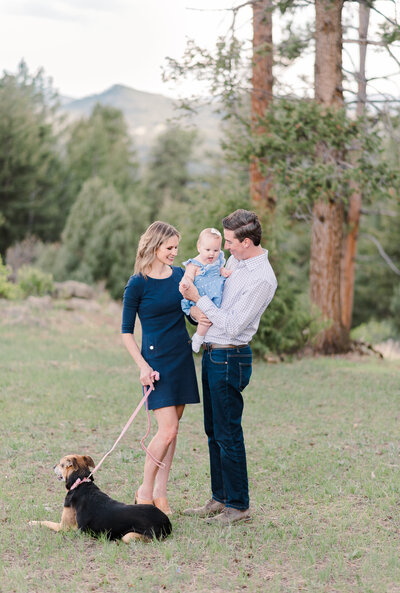 denver family photographers captures outdoor family photos in denver with mother, father, baby and dog together in the woods of the Rockies for summer family pictures
