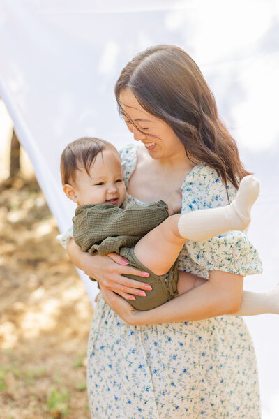 A mother holding carrying her kids with a beautiful smile on there face