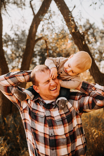 Dad gets tackled by his little one while nikii captures the giggles and laughter during a family photoshoot at Sweet Briar Lake, ND