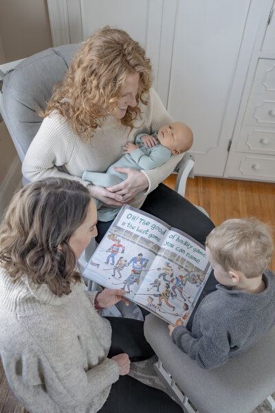 Lifestyle newborn photography session with parents holding baby in front of window with natural light— captured by Alliston and Barrie maternity, newborn, and family photographer.