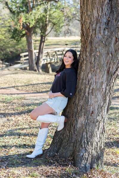 Senior year photos in Dallas, TX showing her unique personality and style in a natural forest setting