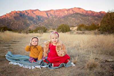 sister portrait in front of the sandias