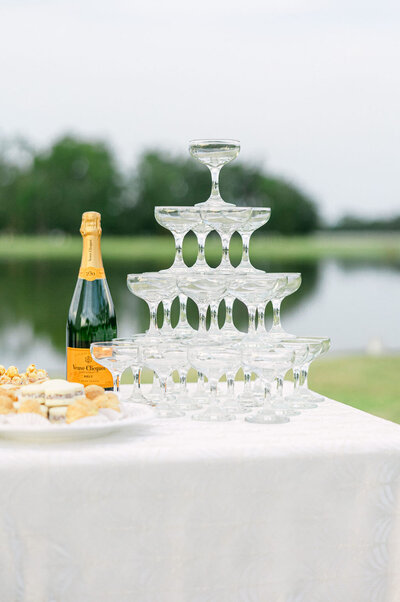 An elegant champagne tower with Veuve Clicquot set against the scenic waterfront at a luxury wedding in Palmetto Bluff. A timeless celebration with refined details