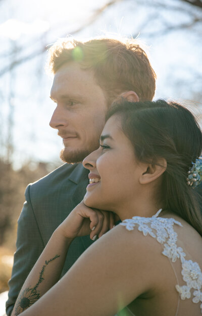 Relaxed portrait of a multi-cultural couple gazing into the future while at Bow's Bridge in Central Park.