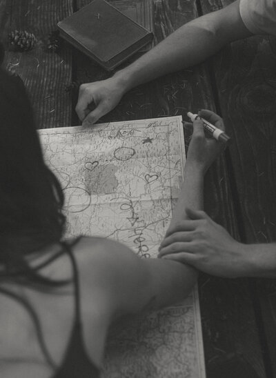 man touching womans arm looking at a map