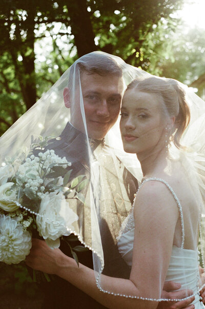 Editorial photograph of a bride and groom under the veil at golden hour captured by California film wedding photographer.