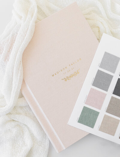 Maternity Photographer,  a sample album and a color swatch card  lay atop a blanket