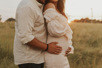 Expecting couple embracing in the field