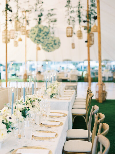 Elegant Alys Beach wedding reception under a sailcloth tent with coastal-inspired design, rattan details, and hydrangea chandeliers.