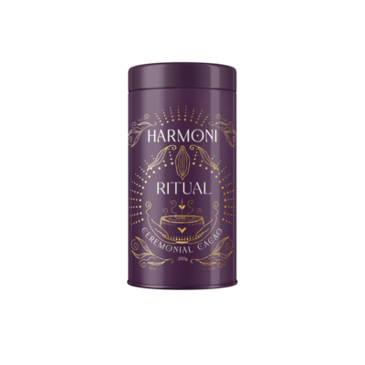 A purple tin labeled "Harmoni Ritual" featuring ornate gold designs and the text "Ceremonial Cacao." The elegant packaging showcases a stylized cacao pod and a ceremonial cup, emphasizing the product's luxurious and spiritual essence.