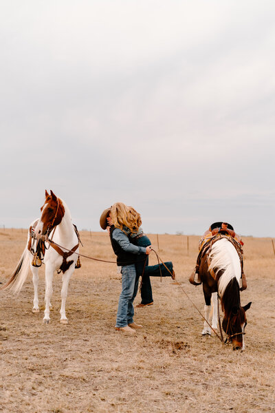 couple embracing by horses