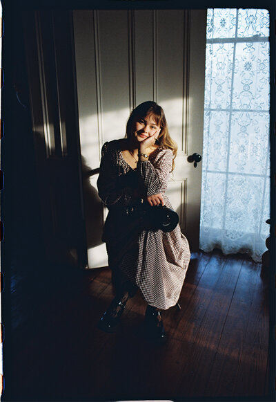 A candid portrait of Ember Claire, the lead photographer, exuding warmth and approachability, reflecting her passion for storytelling through non-intrusive observation.