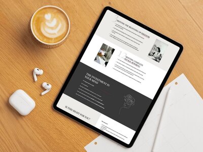 Tablet on a wooden desk next to a coffee and AirPods, displaying a website section detailing 3-month and 12-month coaching programs, with pricing and value breakdown.