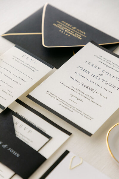 Black and gold letterpress wedding invitation design with gold foil return addressing, paired with black envelopes featuring gold trim - refined wedding invitation ideas for a timeless event.