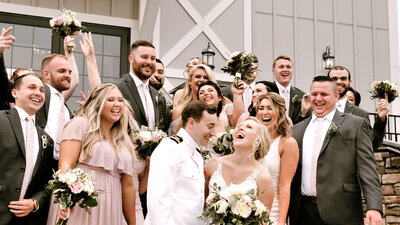Couple laughs together with bridal party outside of a venue in Charlottesville, Virginia
