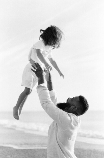 dad throwing kid up in the air, taken by one of the best family photographers naples fl has to offer
