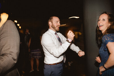 candid wedding reception image of guests dancing
