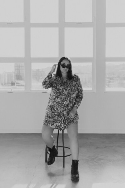 becca luna sitting on stool wearing sunglasses