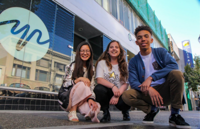 3 teenagers smiling in front of YR media